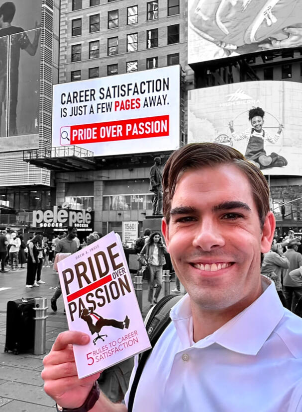 Drew Ingle taking a photo with his book Pride Over Passion and his Times Square billboard to promote his book